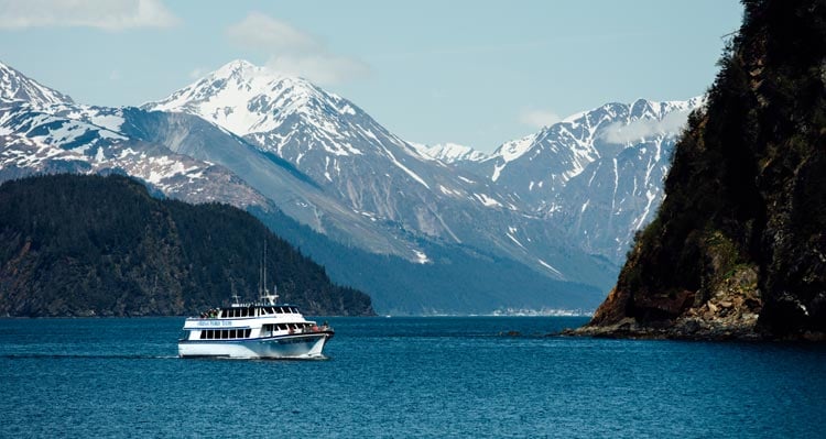 A boat cruises between rocky cliffsides.