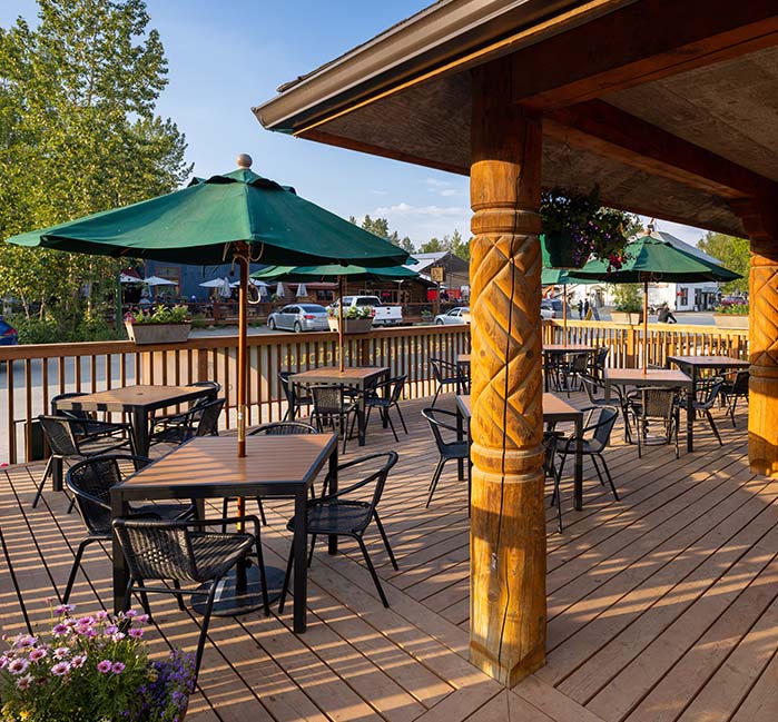 A streetside patio with tables and umbrellas