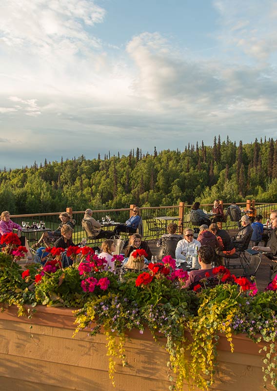 People sitting at an outdoor patio at Talkeetna Alaskan Lodge.
