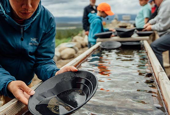 Panning for gold in a trough of water.