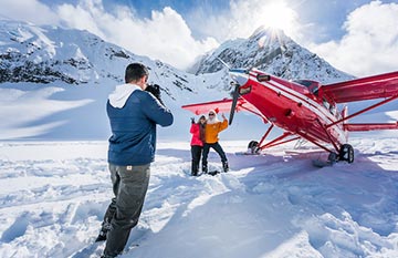 A small red plane landed on a glacier.