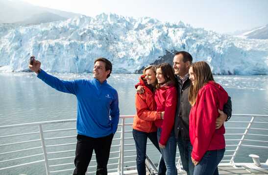 A group of people take a picture on a boat deck.